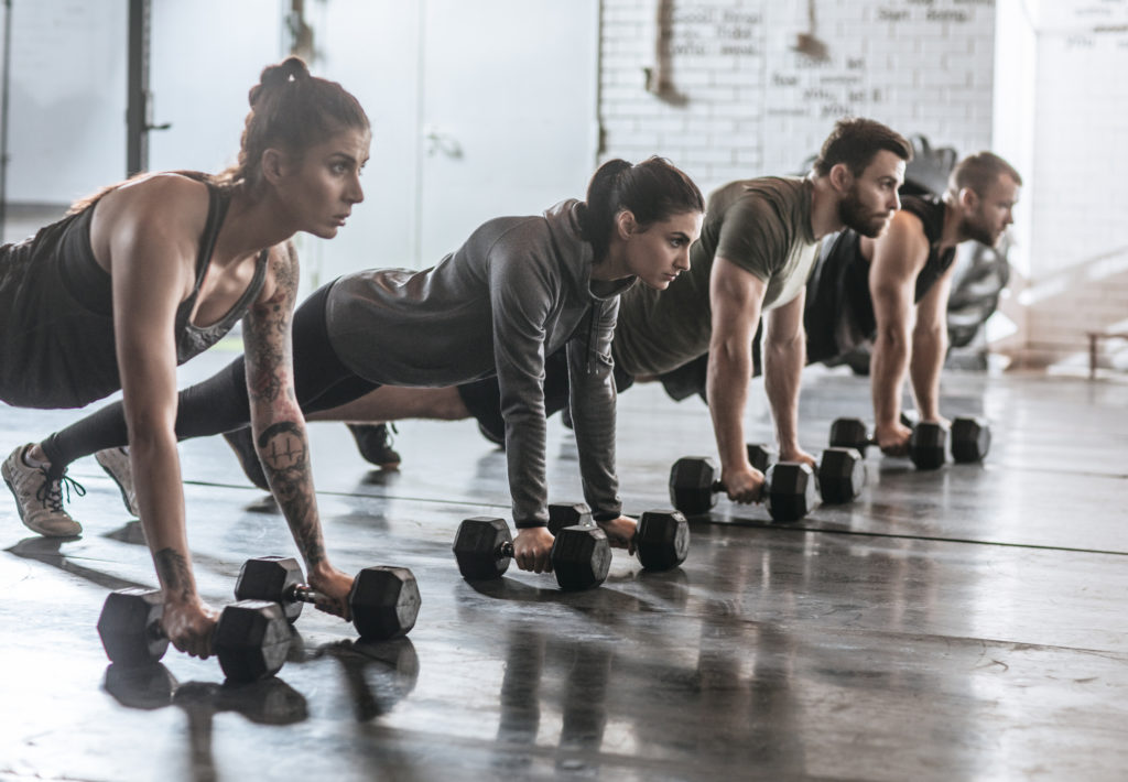 sportspeople doing pushups at gym